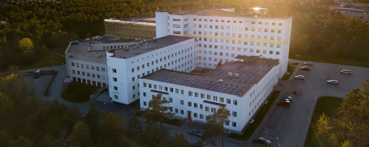 Aerial view of a modern medical campus surrounded by trees at sunset